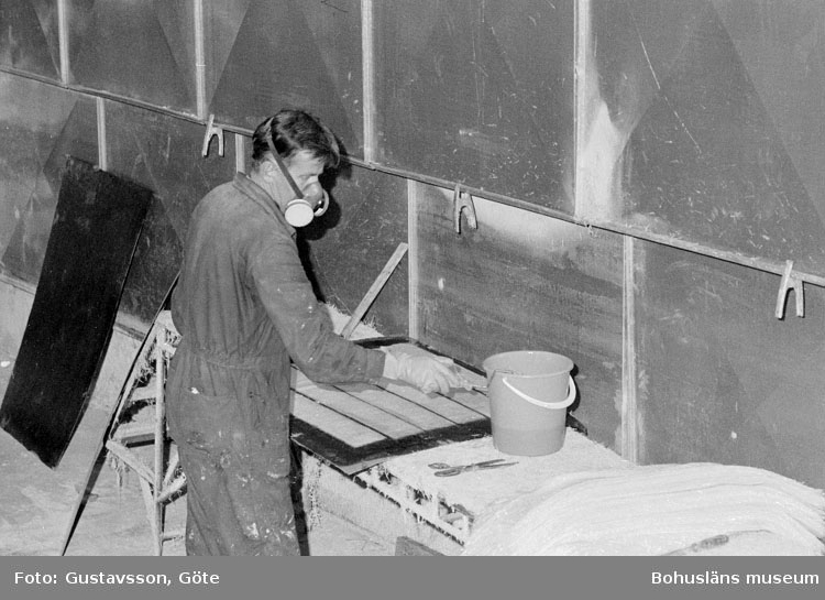 Motivbeskrivning: "Gullmarsvarvet AB, på bilden syns Lars Samuelsson som rullar plast på glasfiberremsor."
Datum: 19801031