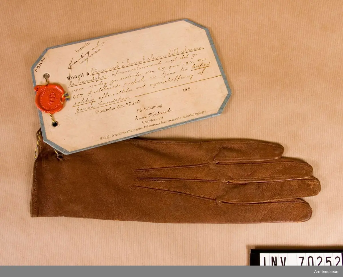Grupp C:I. 
Färgprov m/1911 brunt skinna, vänsterhanske, till glacerade hanskar att tjäna till huvudsaklig efterrättelse vid anskaffning av bruna hanskar.