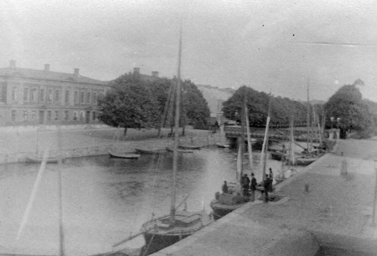 Bilden var uppklistrad på ett A4 papper. 
På papperet under bilden stod följande handskrivna text: "Uddevalla. Hamnen väster "Järnbron" omkr. 1905".