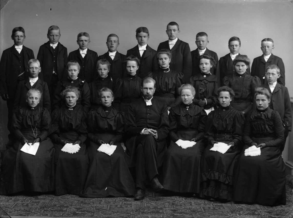 Konfirmandgrupp, troligen från Svinnegarn, Uppland, 1908. I mitten komminister Fredrik Spak (1876-1926).