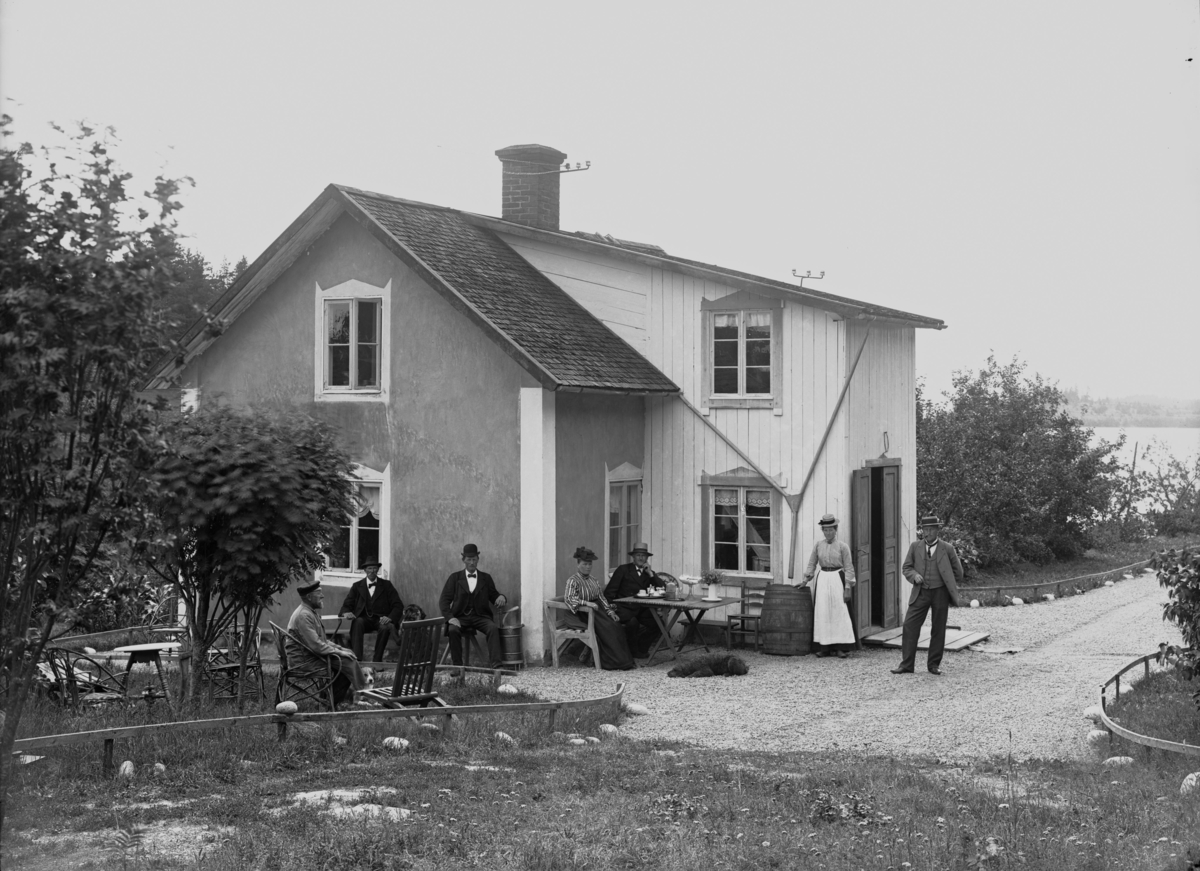 Fem män och två kvinnor vid oidentifierat hus, troligen 28 juli 1905