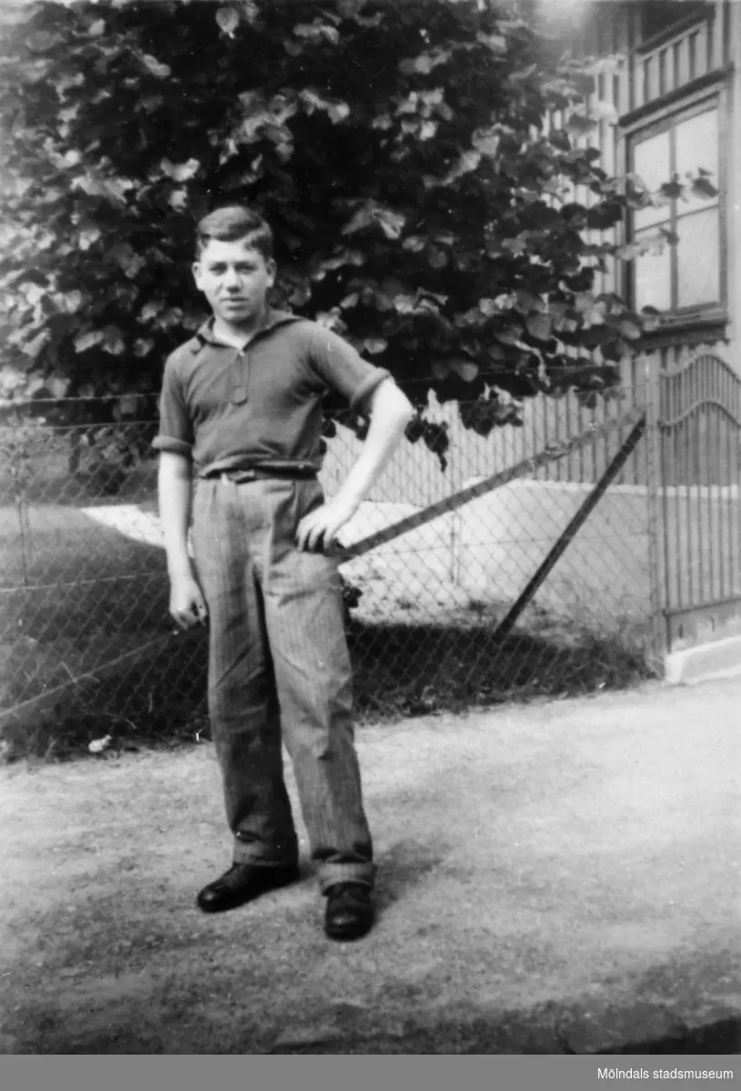 "Karantänsförläggning" på Kvarnbyskolan för överlevande från koncentrationsläger i Tyskland och Polen 1945.  
Skolan fungerade under denna sommar som beredsskapssjukhus.
 
En ung man står utomhus.