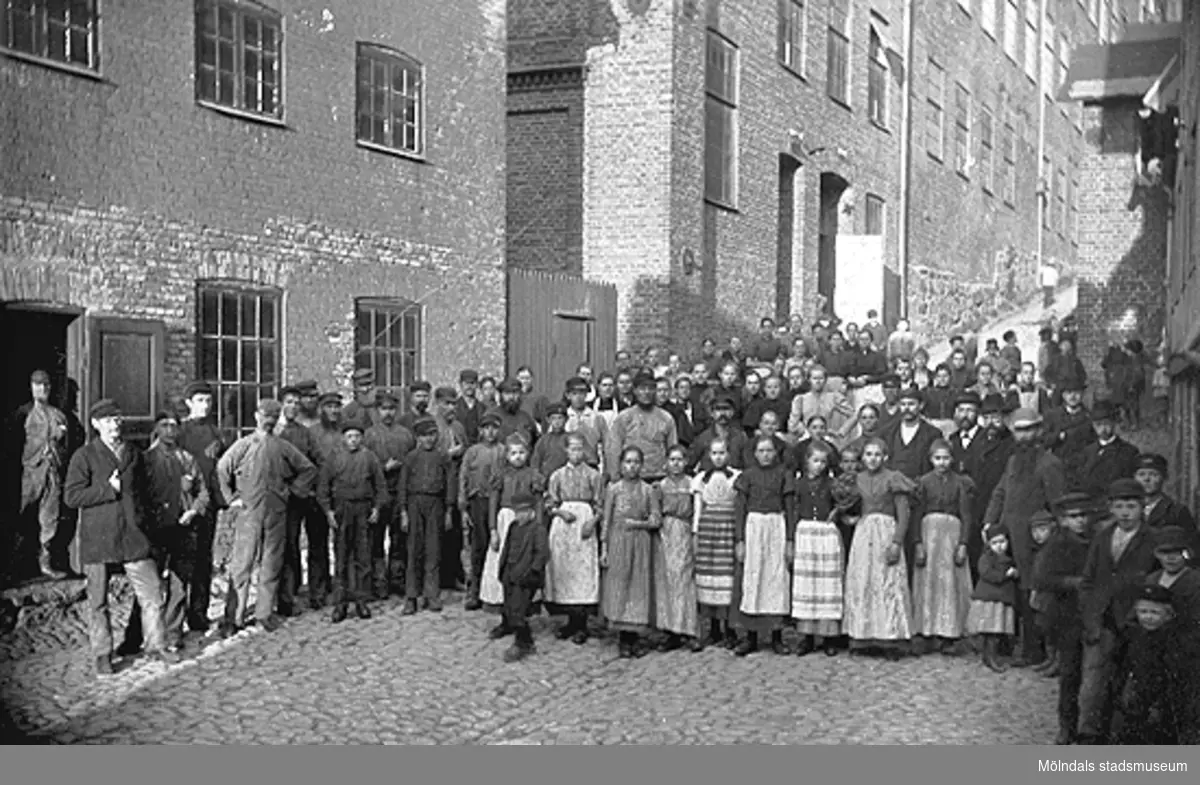 Fabriksarbetare står uppställda utanför Stora Götafors i Götaforsliden. Ca år 1896.