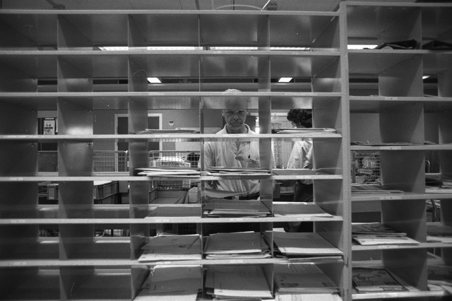 Lantbrevbärare Reinhold Andersson sorterar post inne i
sorteringsdelen på en postanstalt. Tillhör en dokumentation av en
lantbrevbärare i trakten av Valdermarsvik av fotograf Ove Kaneberg.