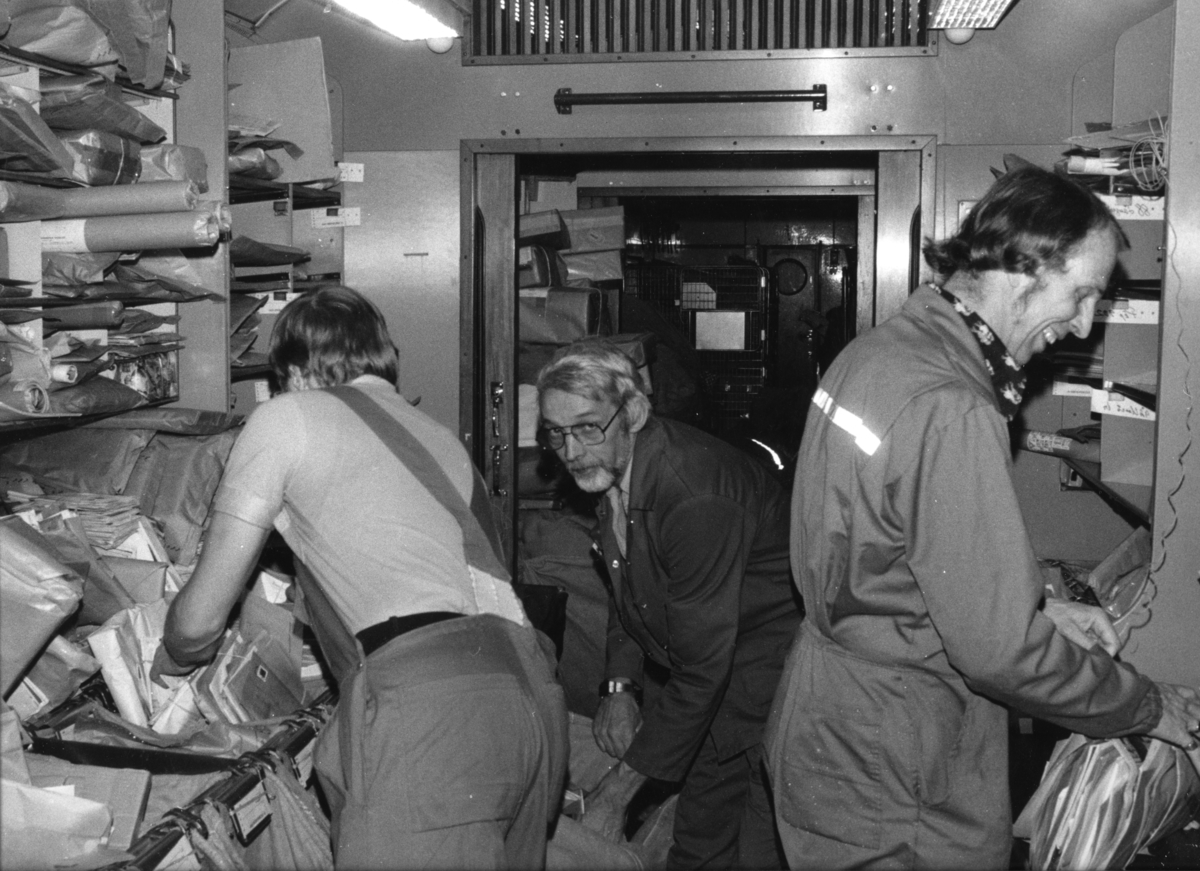 Fotografi föreställande interiören i postkupé nr 811. Tre överpostiljoner från Östersund sorterar post en decembernatt 1982.