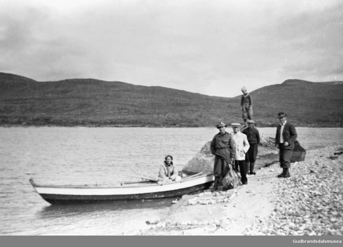 Seks personer ved vannkanten hvorav en kvinne i båt, de er på vei til Aursjøen.