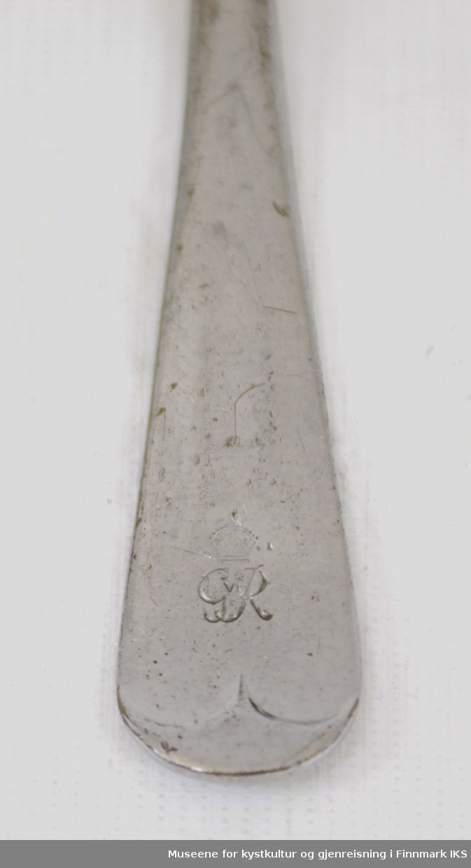Gaffelen er laget av forkrommet stål, og består av fire lange tinder festet til et skaft i samme materiale. På framsiden, nederst på skaftet er det en innskrift med GR IV, for kong Georg VI (regent 1936-1952). På baksiden av skaftet er det et stempel med Stainless Chromium Plate, Sheffield England.