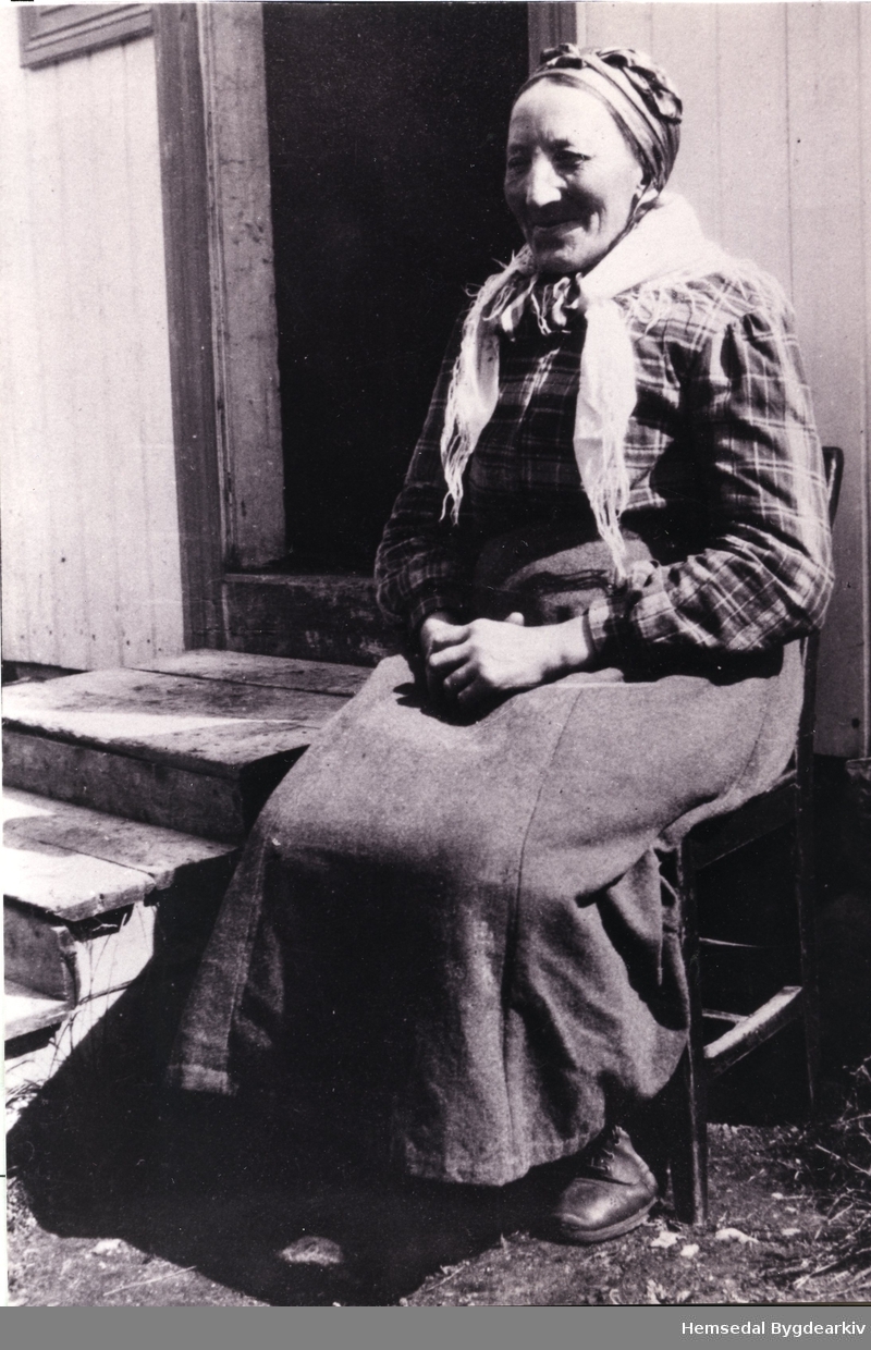 Guri Liheim, fødd Skøyten (1873-  )
Guri vart kalla "Store-Guri". Her sit ho utanfor huset sitt.
Biletet er teke i tidsrommet 1940 - 1950.
