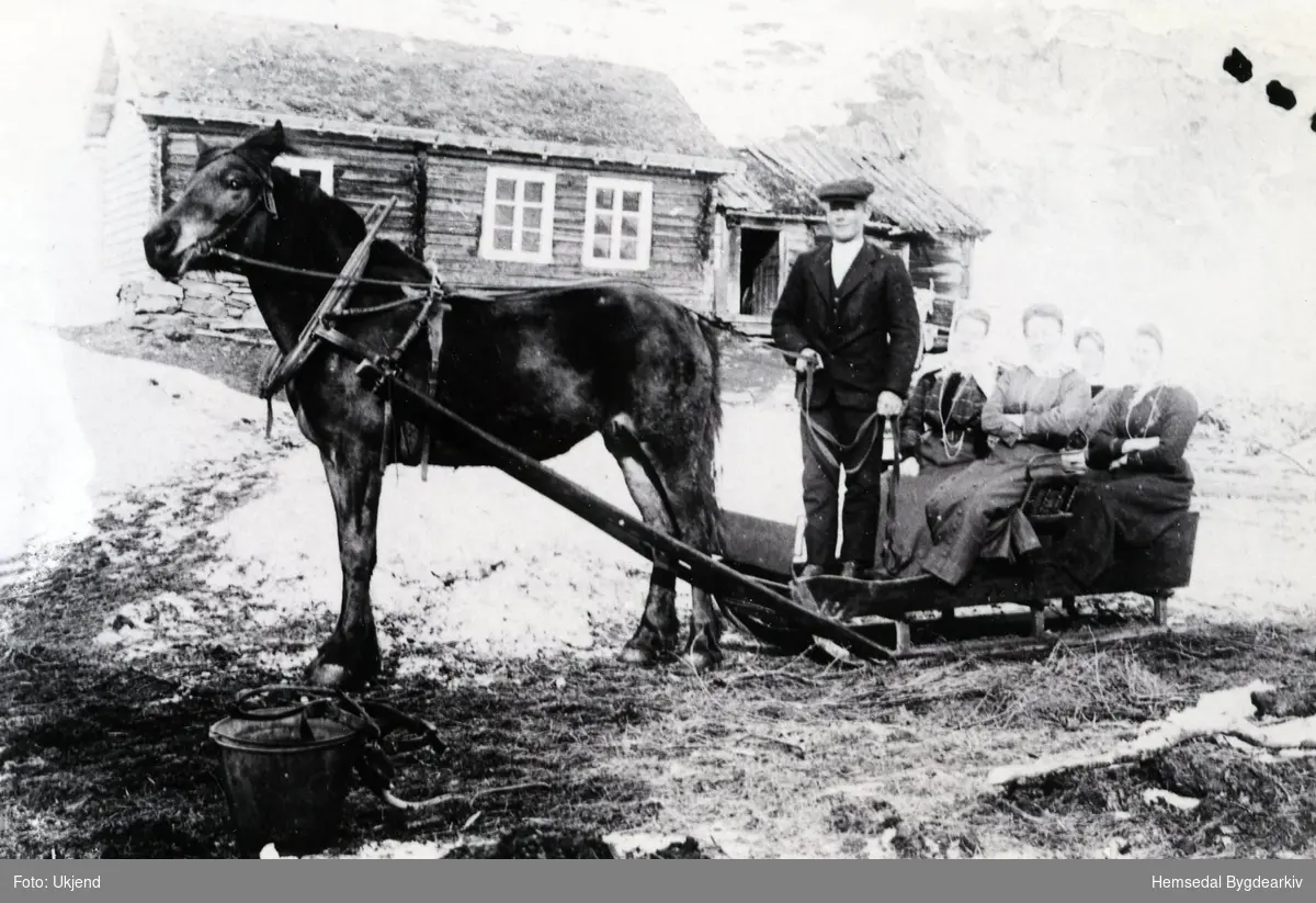 Ola T. Brandvold (1876-1953) med 4 damer på sleden. Biletet er teke i tunet på garden Brandvoll (Søpågarden), 83.2.
