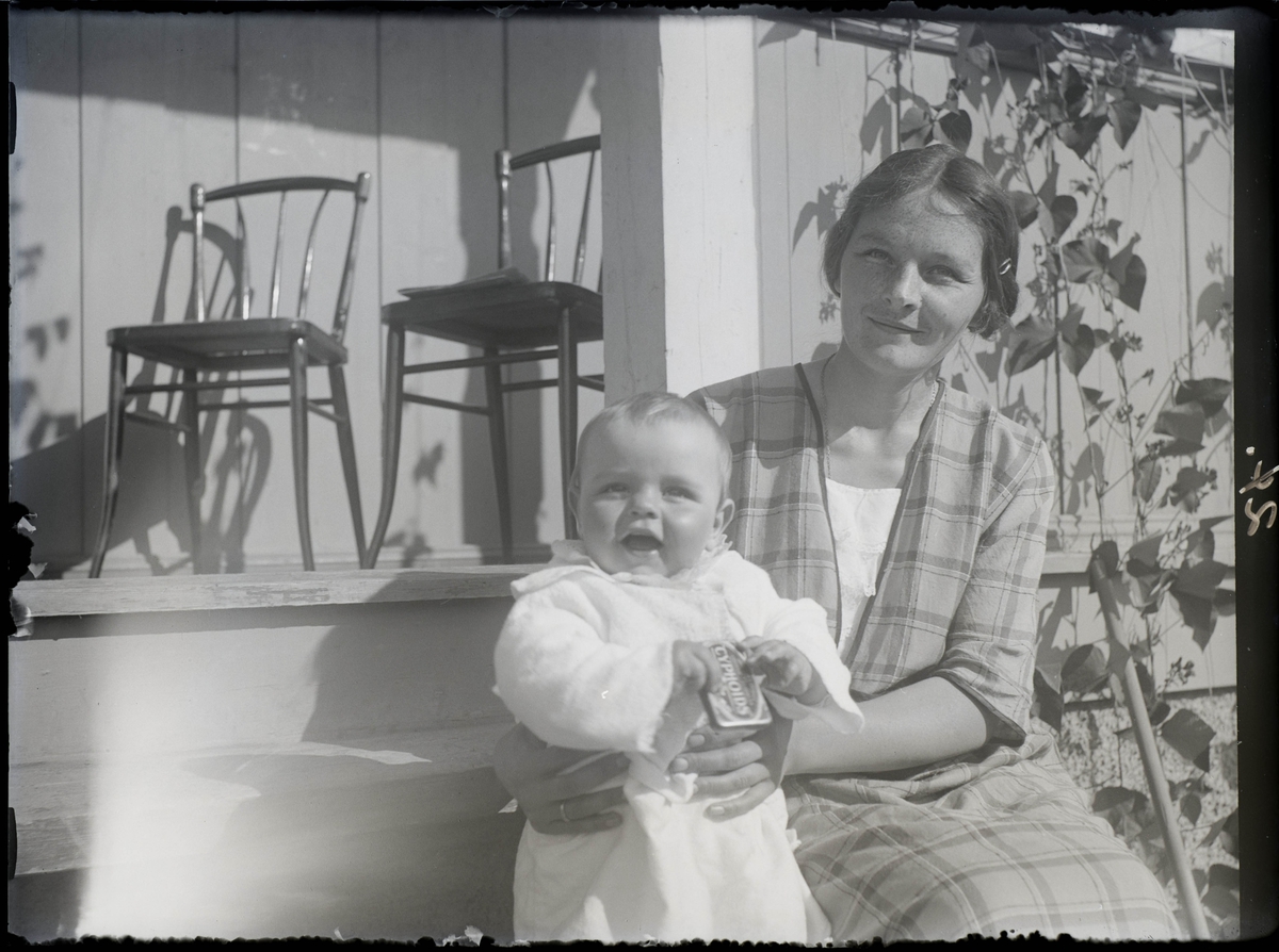 Kvinne og liten gutt på veranda.