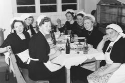 Syv kvinner rundt et bord på kjøkkenet i ungdomshuset "Fram"