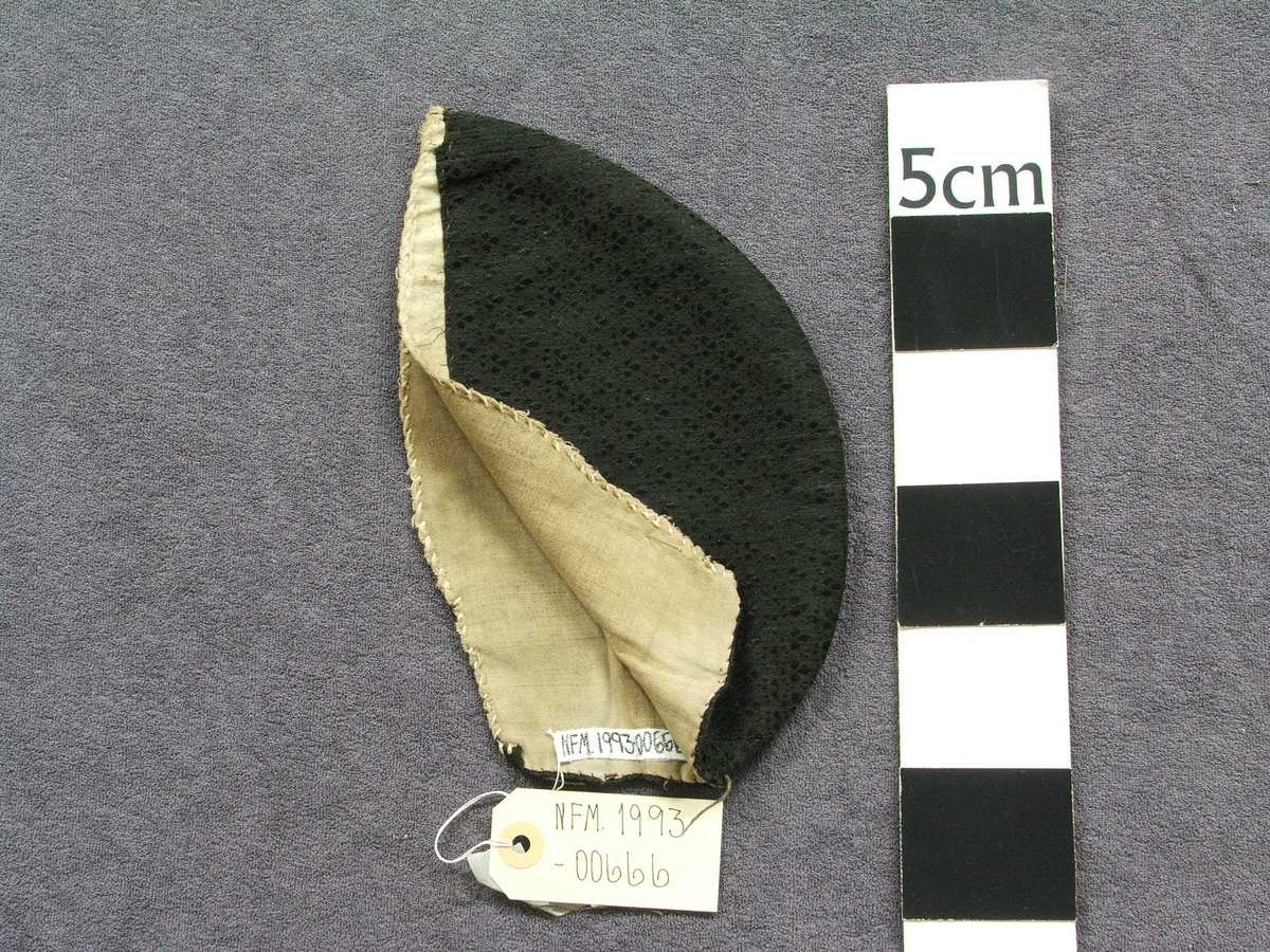 Mønster i stoffet som "sydd" : 3-blad-form med prikkar rundt.