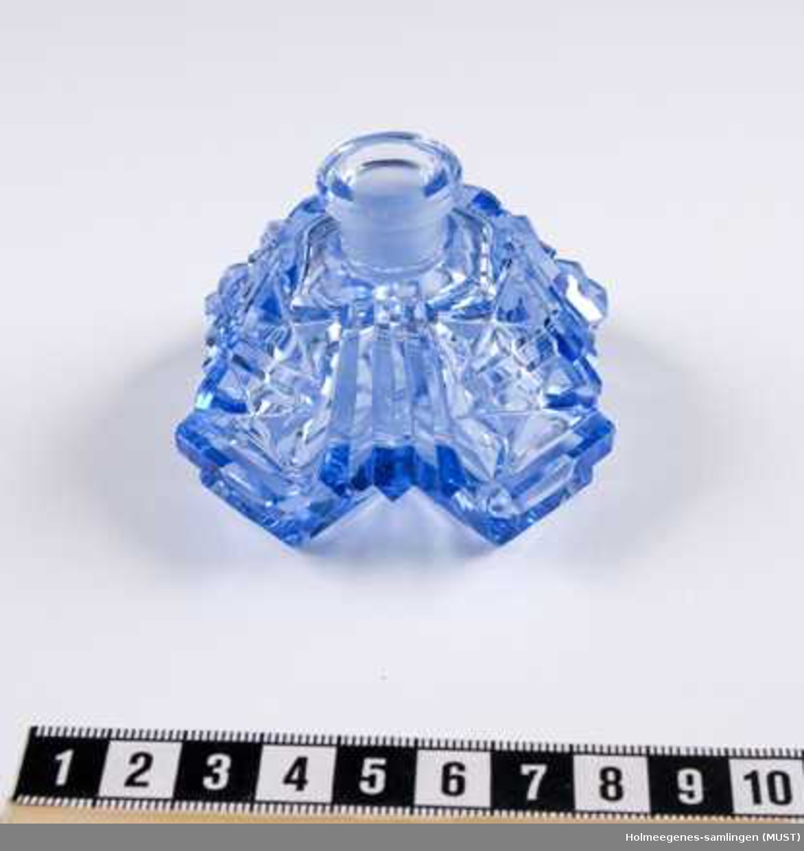 Parfymeflaske av slipt blå krystall, merket med Made in Czechoslovakia, etset inn under, mer modern merke. Stopperen mangler. Forseggjort flaske. Fasettsliping.