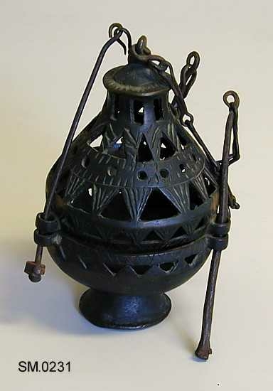 Skålformet underside. Med stett. Lokket høyt, spisst og gjennombrutt. Med 3 lenker i karet og en i lokket.
