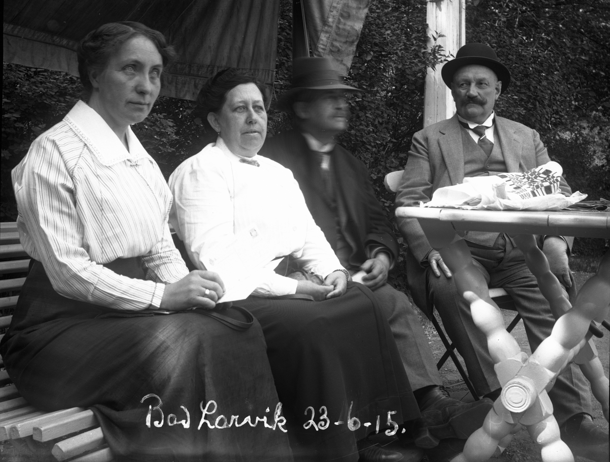 To kvinner og to menn ved bord i hagen på Larvik bad 23/6-1915