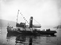 Båt med mennesker ombord.
Slepebåten "Tinfos".