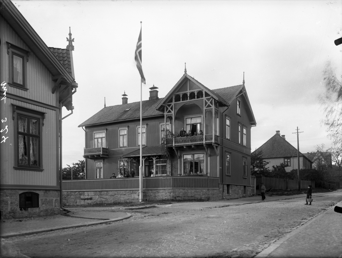 Mennesker i et stort hus, fotografert bl.a. på terrassen. Kullgrosserer Ejnar Stensruds hus i Lundegaten, sør for Skien prestegård.