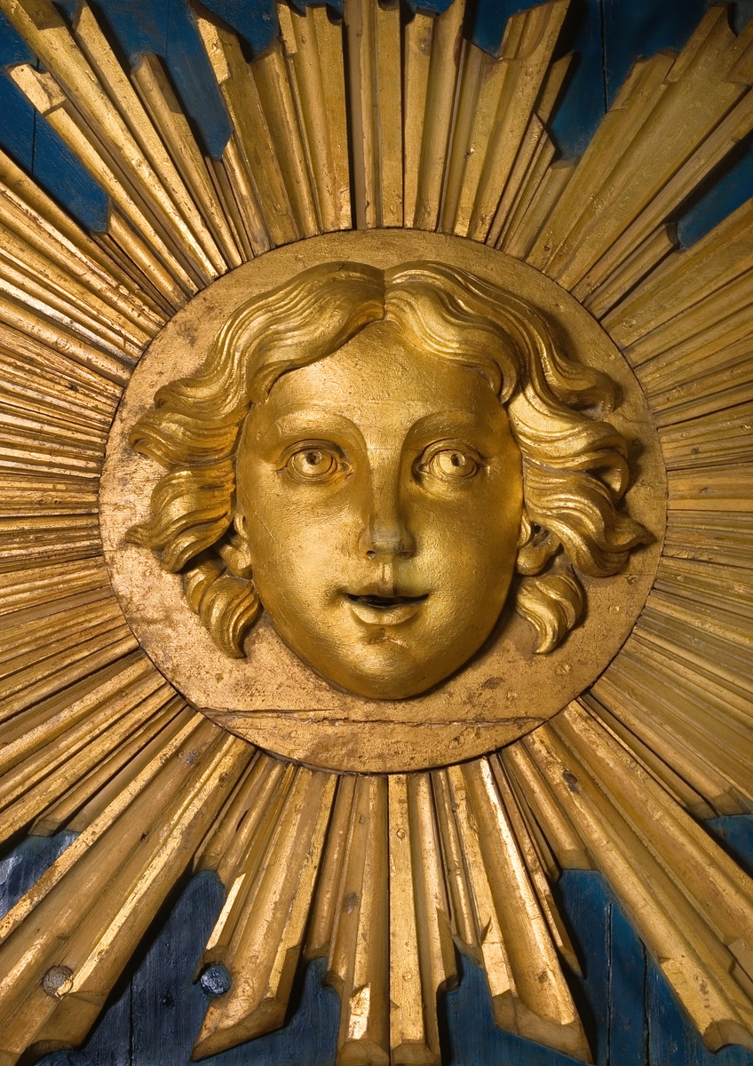 Skupturdetalj från Amphions akterspegel. Förgyllt manshuvud omgivet av solstrålar.
