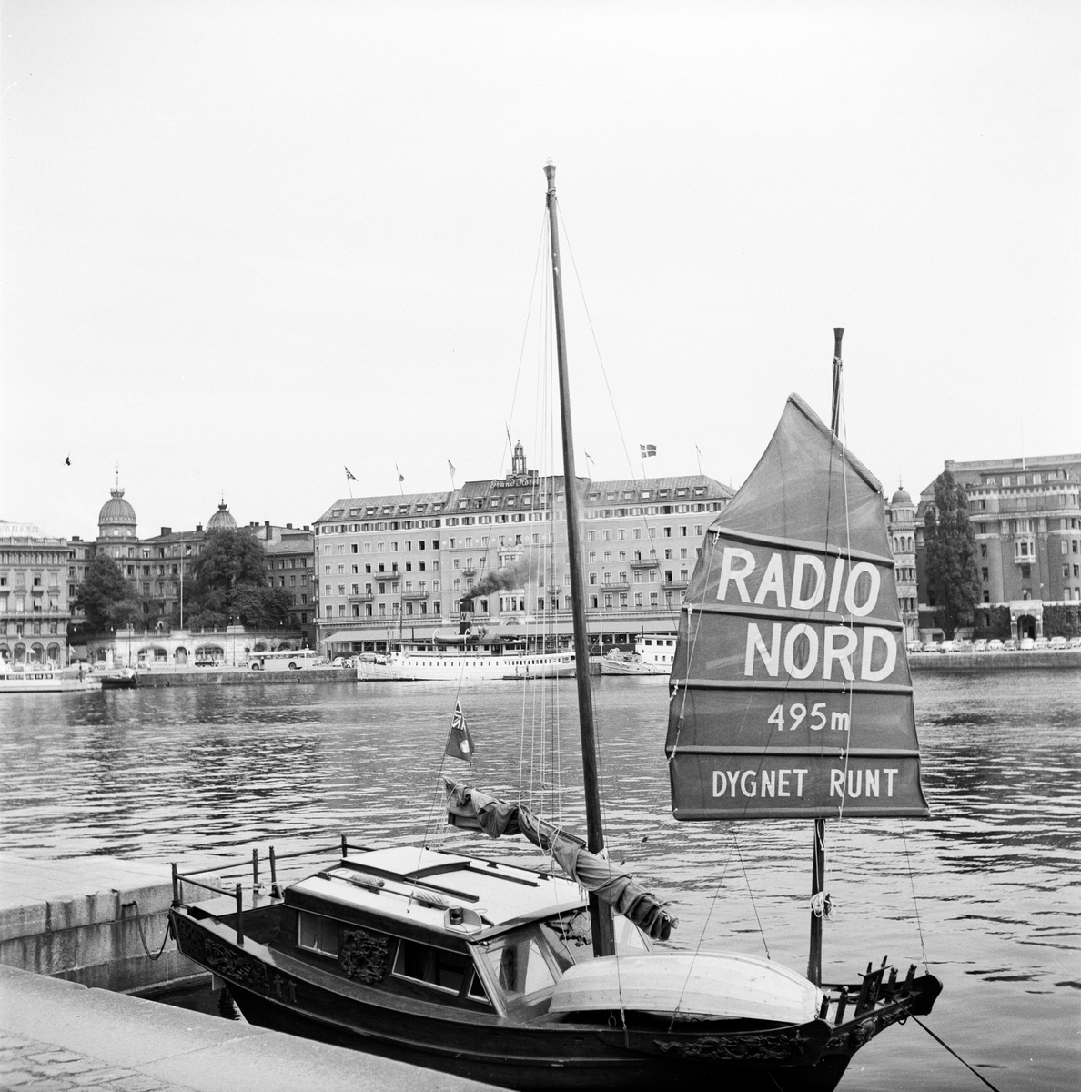 En liten båt vid kajen gör reklam för Radio Nord. Stationen sände från ett  fartyg, M/