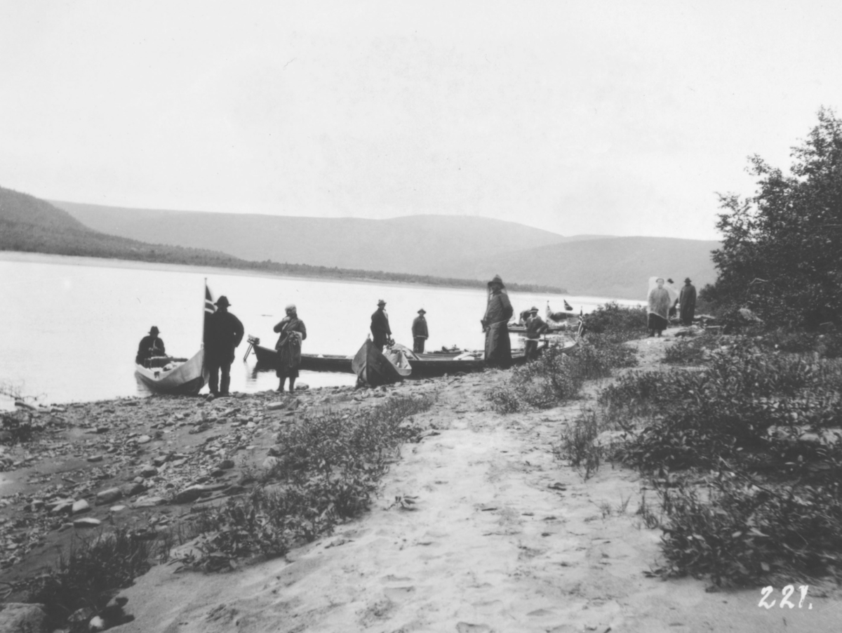 Jordbrukskomiteen på Stortinget foretok en reise til Finnmark i 1935. Kleppe var med og ga bildene sine fra denne turen til fylkesmann Gabrielsen etter krigen. Her har Kleppe fotografert en gruppe mennesker nede ved elva ved siden av noen elvebåter som er dratt opp på bredden.