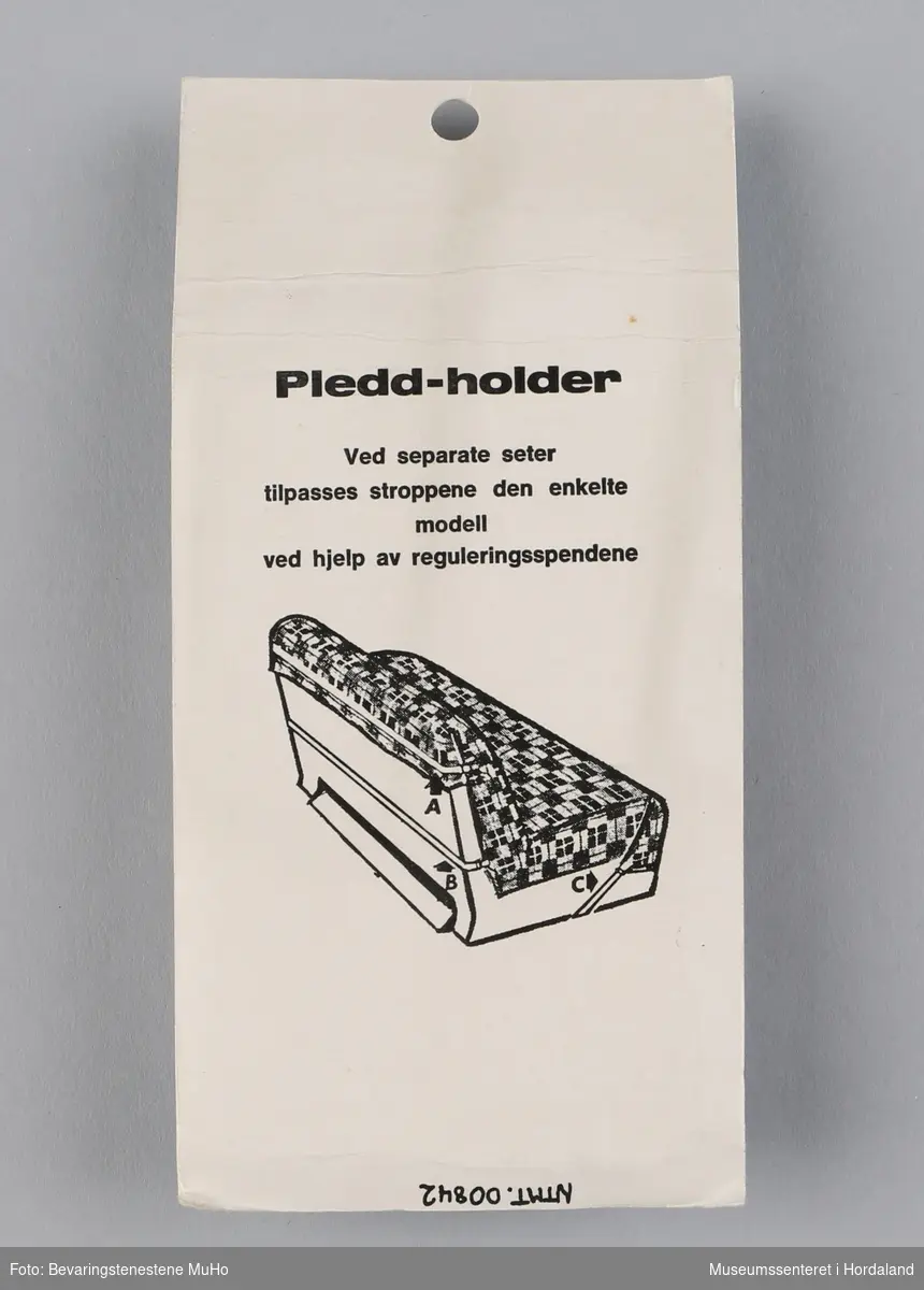 Eit sett pleddholdarar frå Cebelle, i uopna emballasje. Brukast til å feste pledd til t.d. ein sofa. Produsert av Oslo Baand & Lidsefabrik.