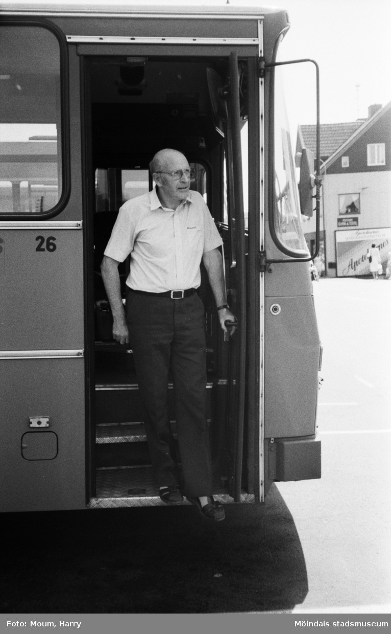 En manlig chaufför stiger ur Kålleredsbuss vid Gamla Riksvägen i Kållereds centrum år 1983.