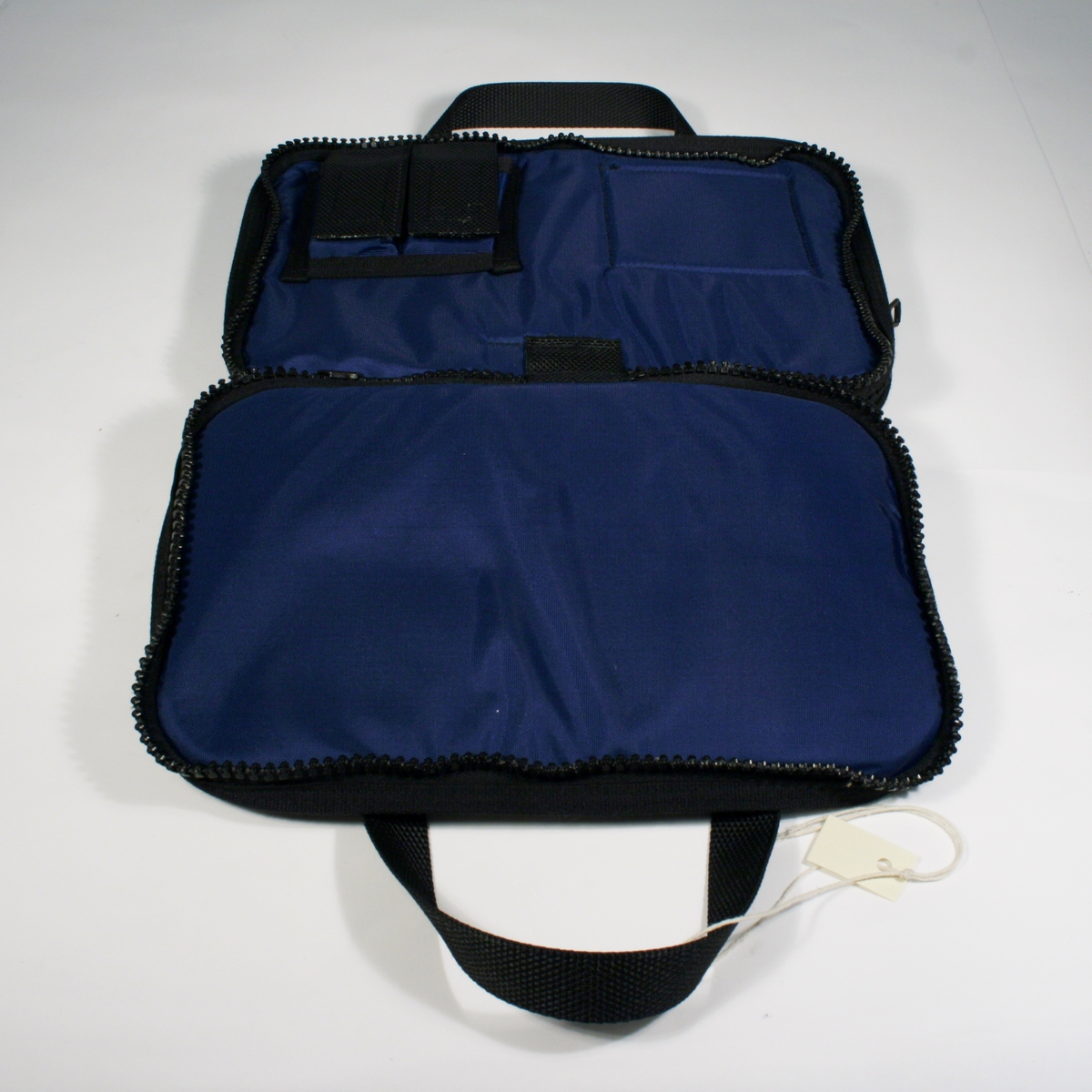 Blå rektangulær bag med sorte detaljer til oppbevaring av skrivesaker, forelegg etc. To lommer lukkes med glidelås og håndtak.