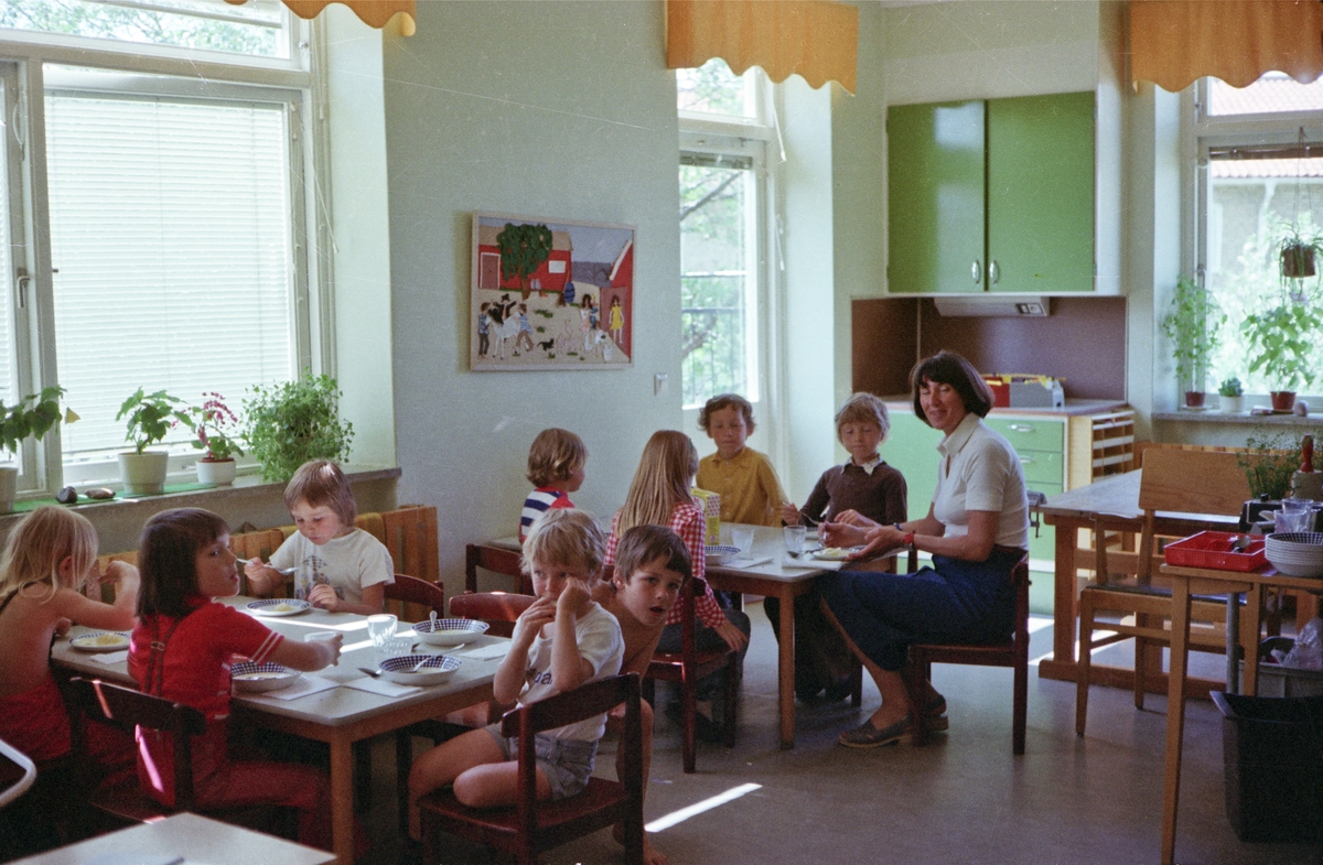 Barnverksamhet i Huskvarna. Barn och lärare har samlats kring borden för en måltid.