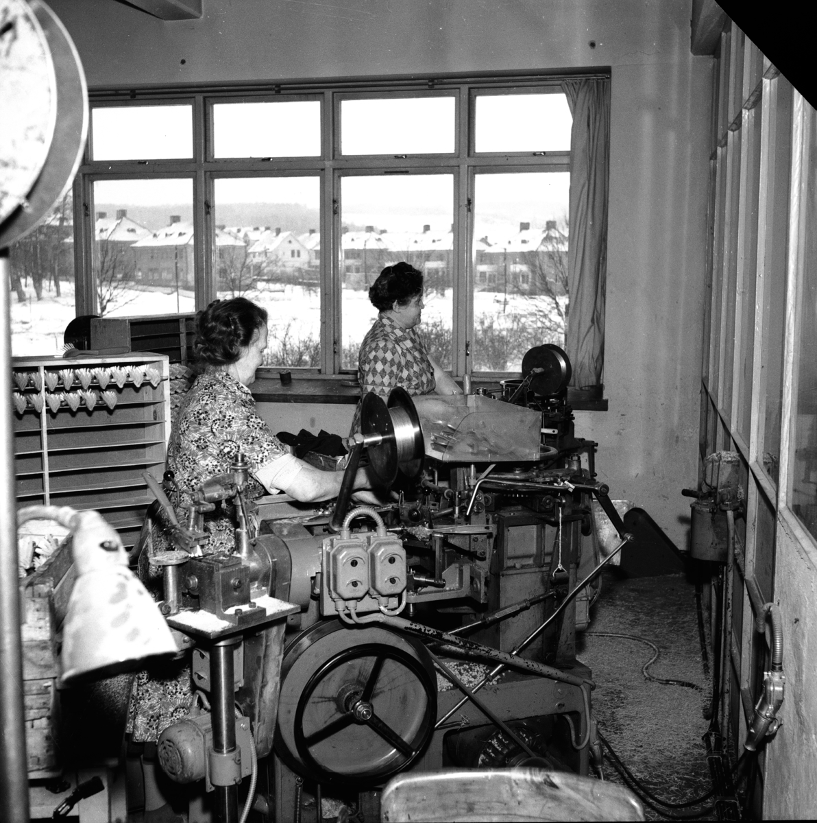 Två kvinnor sitter vid sina maskiner på Huskvarna Borstfabrik och arbetar.