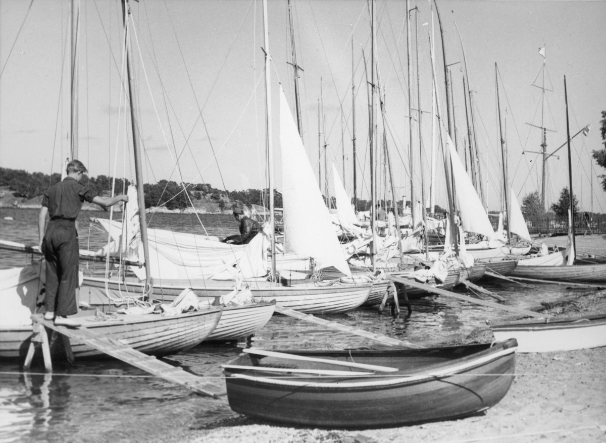 Övrigt: Från Juniorernas Sandhamnsregatta 1944, Sandhamn; dessa seglingar ägde rum 28-30 juli. Fotografiet återgivet i KSSS årsbok 1945 s 158 och i Till Rors årg. X (1944) nr 7 s 264.