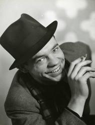 Ung mann med hatt som røyker.