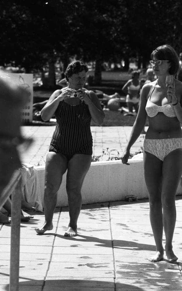 Vite negern 19 juli 1966

Ett utomhusbad med en kvinna som är klädd i randig baddräkt och en kvinna som är klädd i ljus bikini och glasögon i förgrunden. Kvinnan i bikini bär en glass i sin vänstra hand. Ytterligare personer skymtar i bakgrunden.