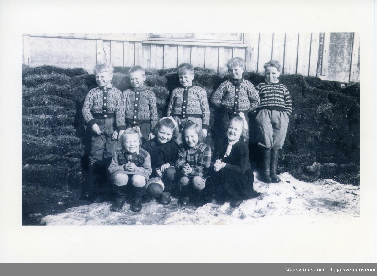 Første klasse i 1952 foran den gamle skolebygningen i Skallelv. Foran fra venstre Nelly Huru, Wally Johansen, Åse Snevoll, Randi Harjo. Bak f.v. Arnold Huru, Bjarne Rimala, Håkon Bauna, Kjell Harjo og Egil Sundelin.