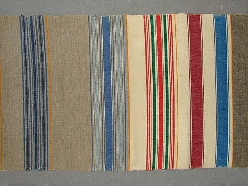 Bolstervarsprov i olika randningar och olika färgställningar. Varp i bomull och inslag i ullgarn, med undantag av en bit där även inslaget är i bomull. Bolstret vävdes upp för en inventering på 1940-talet.