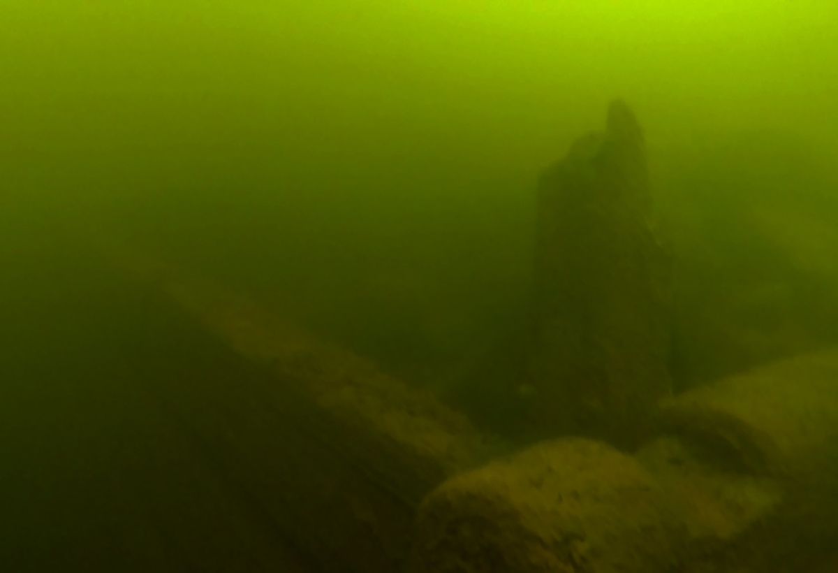 Uppstickande timmer i den övre delen av stenkista i vattnet utanför Karlshäll, Luleå.