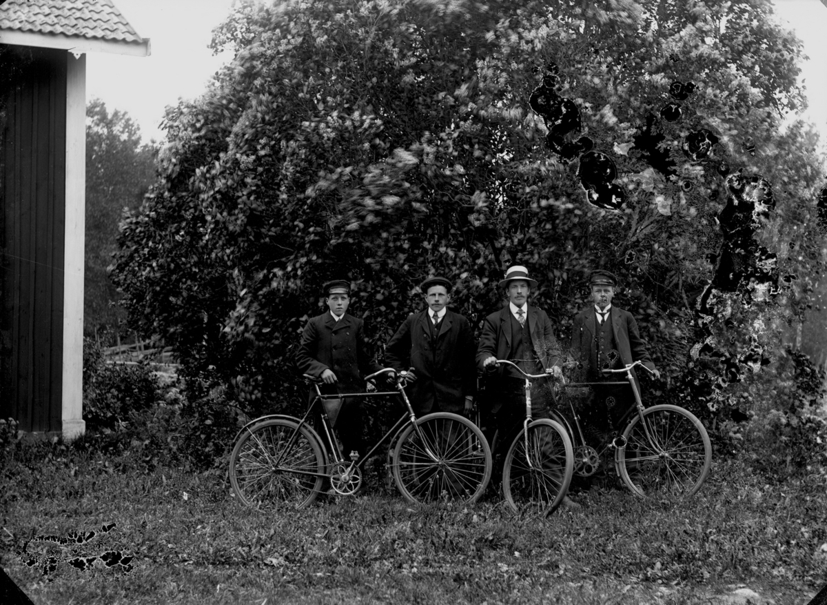 Fyra män med cyklar.