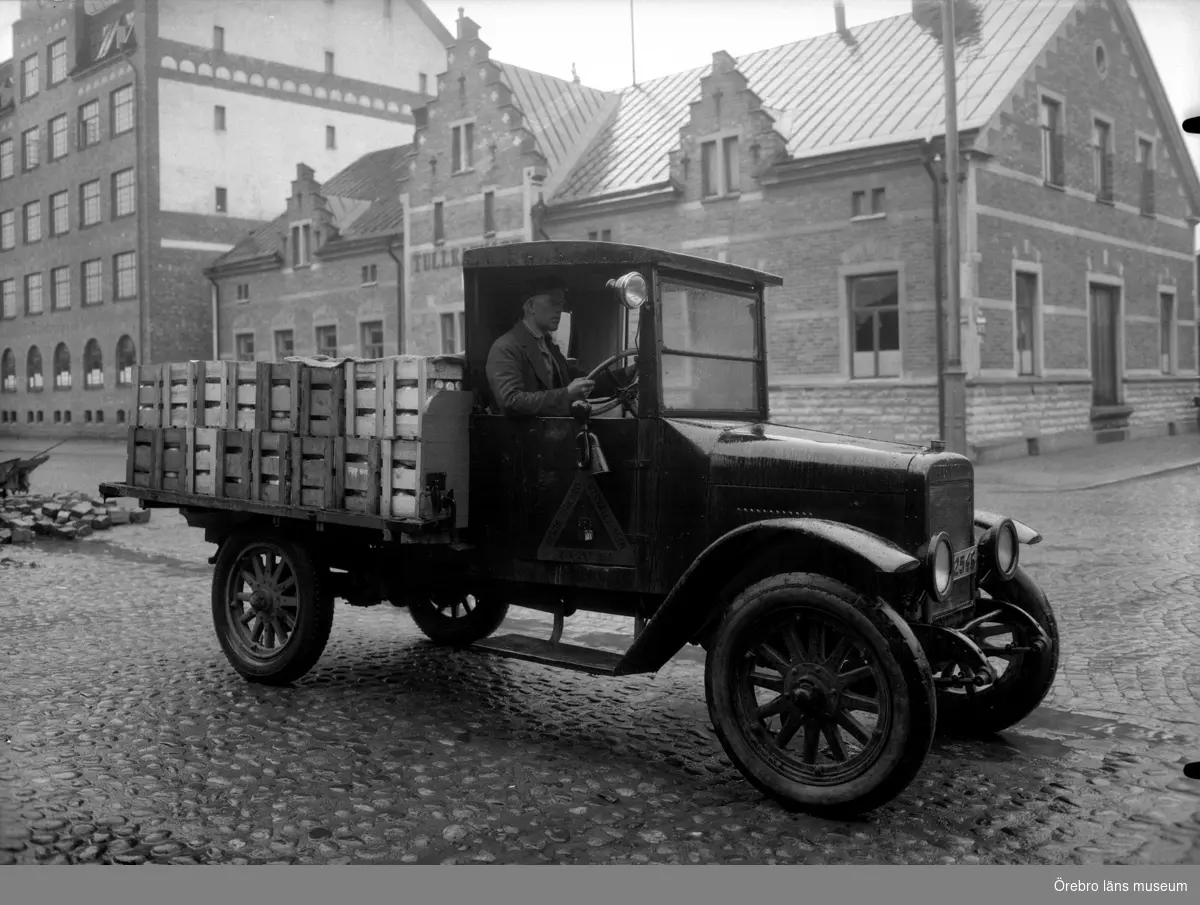 Fabriksbyggnader, en lastbil. 
Lastbilen är en International med reg.nr. T2546. År 1930 ägdes den av trädgårdsmästare Karl Pettersson, Älvtomta, Örebro. 
Adressen är Östra Bangatan 34, den gamla tullkammaren. Till höger går Magasinsgatan.