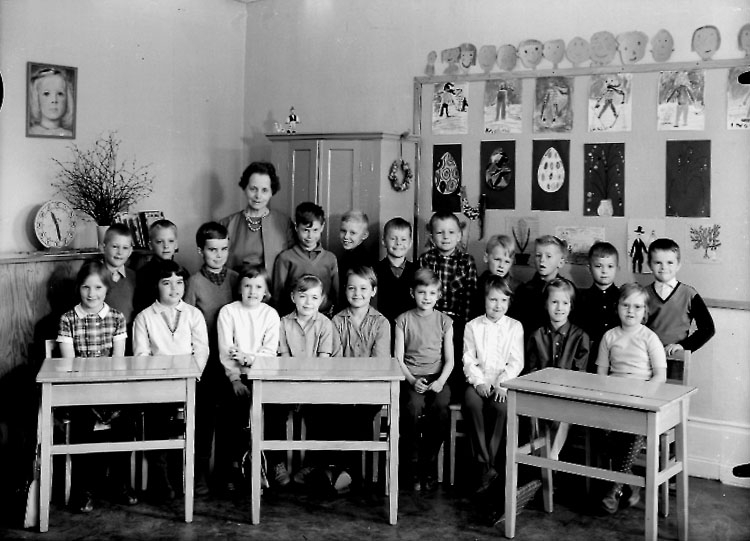 Stureskolan, klassrumsinteriör, 20 skolbarn med lärarinna fröken Eva Risberg.
Klass 1ac, sal 4.