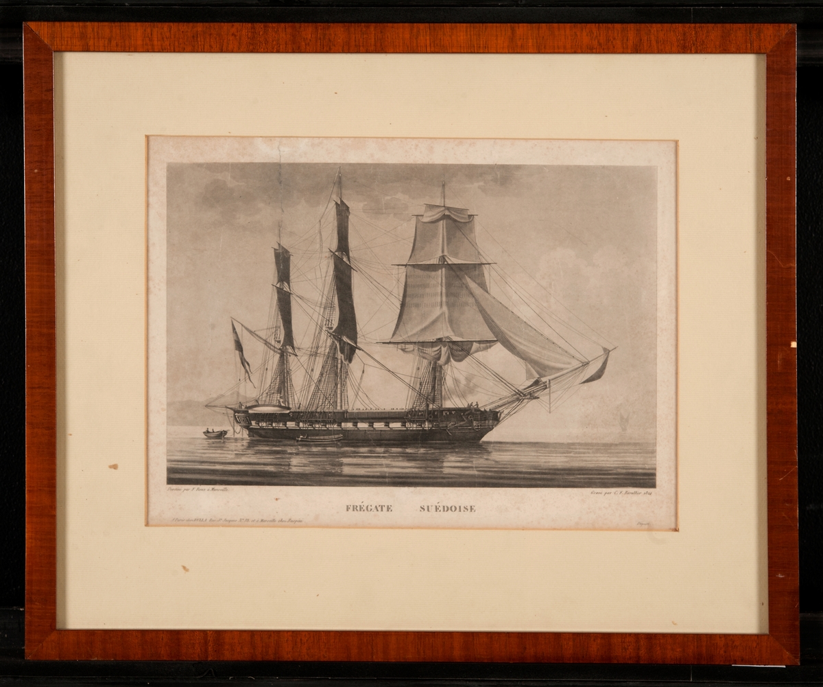 Gravyr under glas, i passepartout, fregatt (1824) sedd mot styrbords sida, i stiltje, tretungad unionsflagga med andreaskors under gaffeln.

Ram: Mahogny