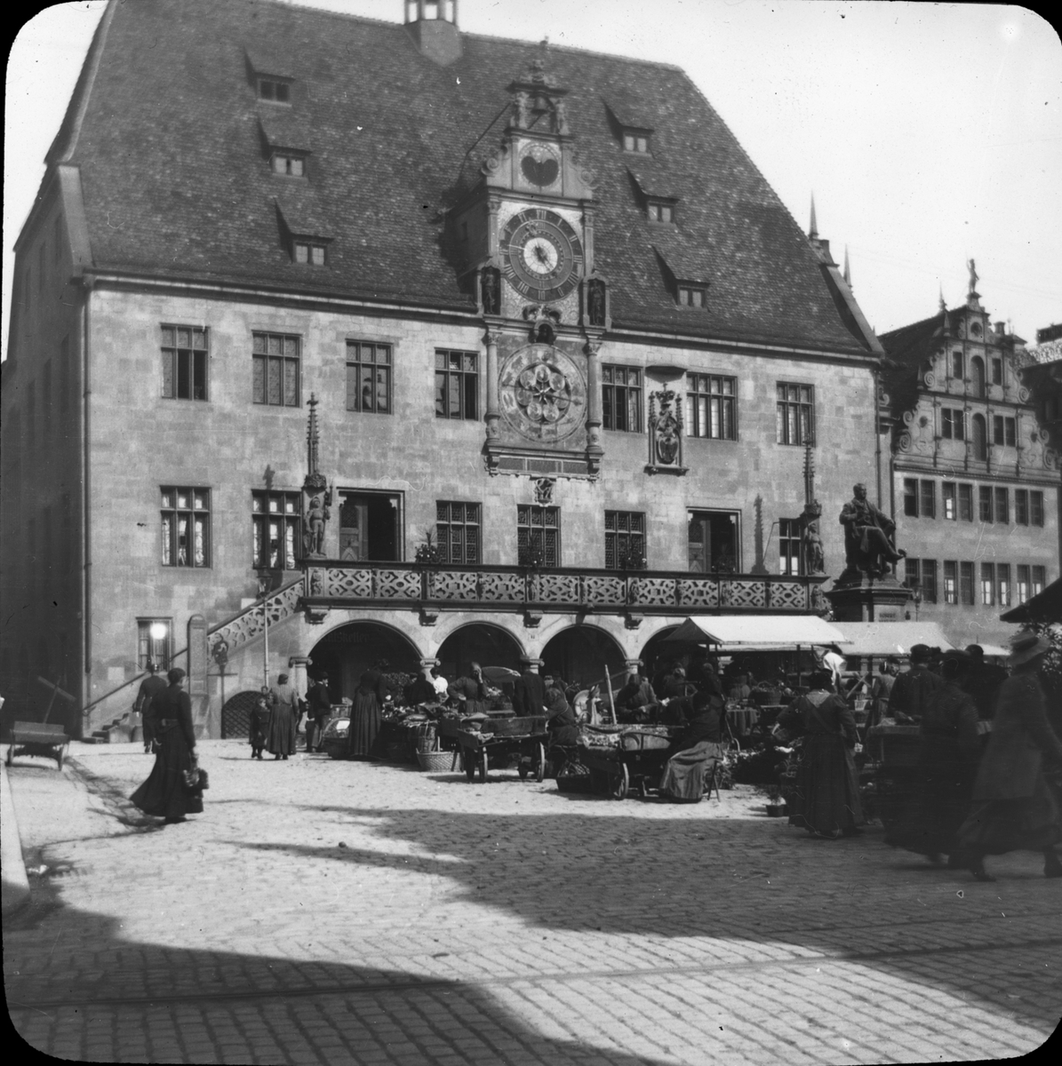 Skioptikonbild med motiv av marknad framför rådhuset i Heilbronn.
Bilden har förvarats i kartong märkt: Resan 1908. Heilbronn 4. Wimpfen 5. Text på bild: "Marplats".