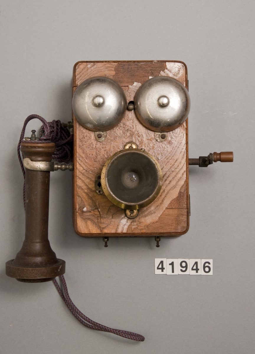 Telefonapparat, väggmodell för lokalbatteri. Senare omändrad med kolkornsmikrofon. Kompletterad med hörtelefon. Hörtelefonen är märkt: 3279.