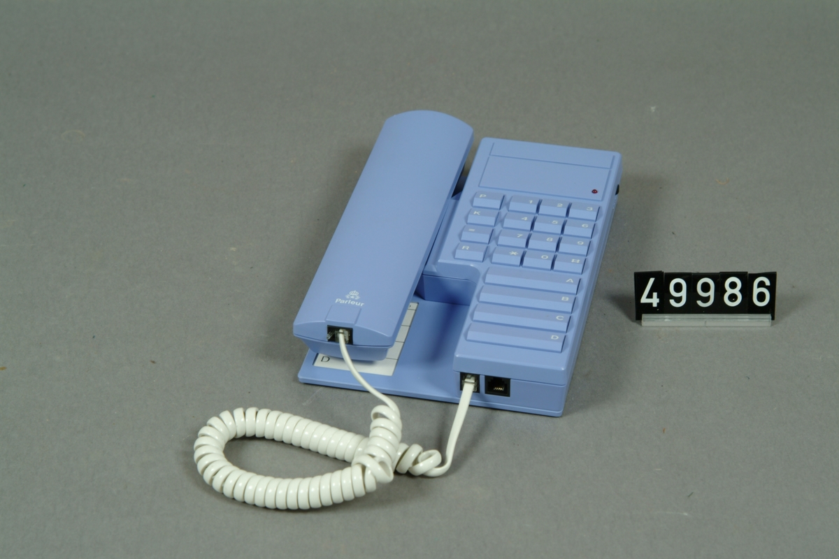 Lila telefonapparat i originalkartong, med bruksanvisning, fyra namnval, tio kortnr. repetition och tonval.