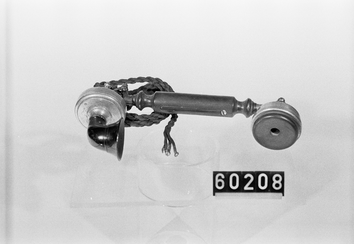 Handmikrotelefon med tangent, av aluminium, med utanpåliggande snöre. Tillhör telefonapparat LME375