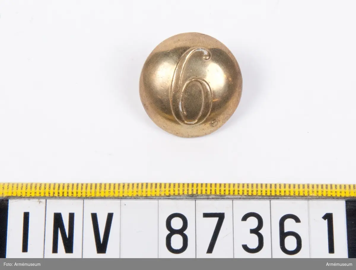 Grupp C.
En knapp med siffran 6.
Tillverkad av L. W. Boström, Stockholm.
