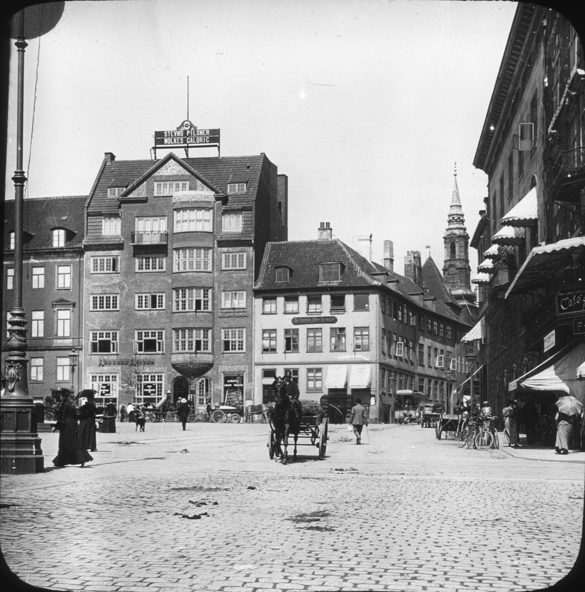 Skioptikonbild med torgmotiv från Gammeltorvet i Köpenhamn. I bakgrunden St Petri kirke.
Bilden har förvarats i kartong märkt: ?