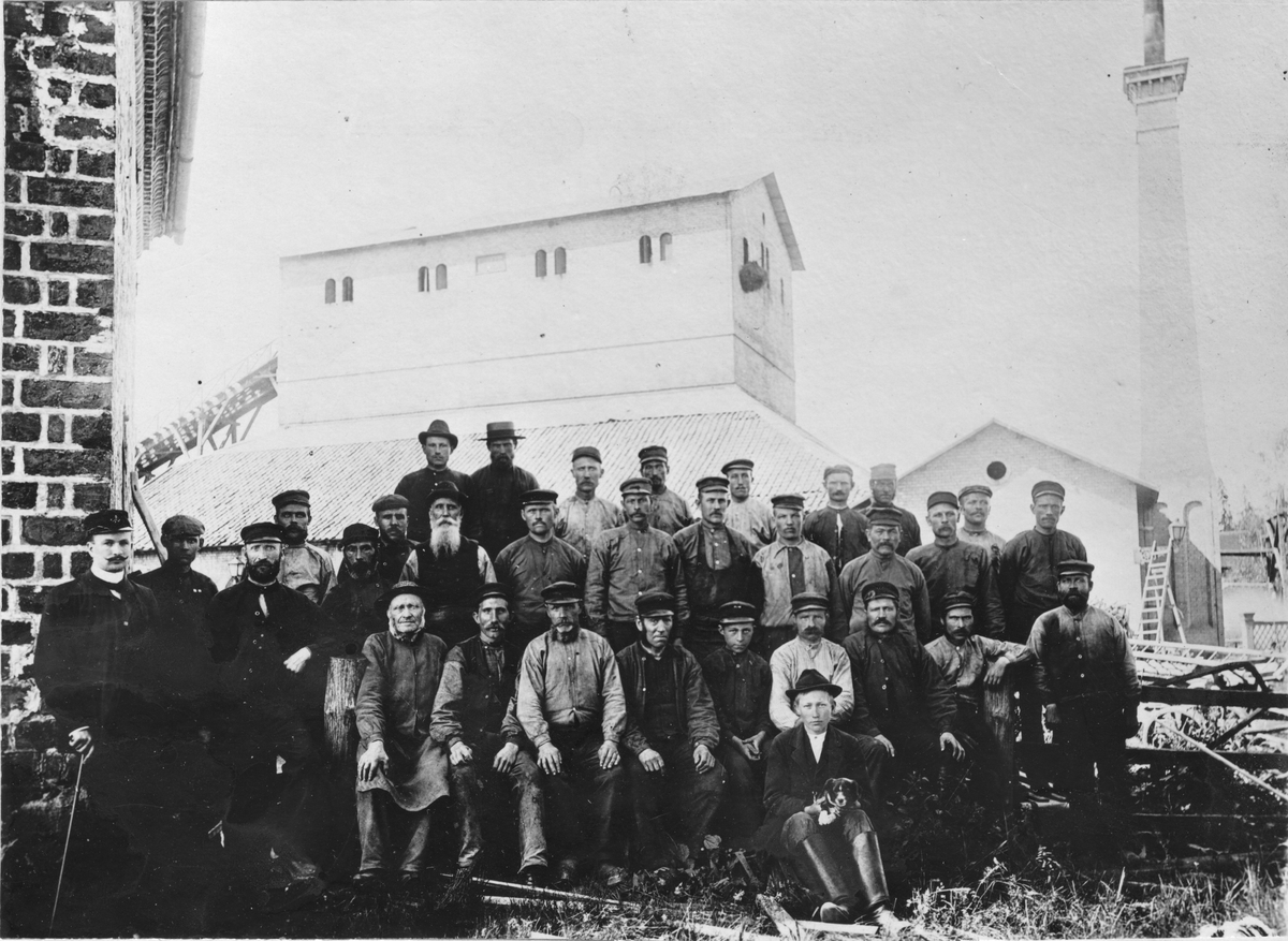 Tobo Masugn. Hyttan och arbetarekåren 1896. Mannen längst till vänster är bruksbokhållaren Eugen Beausang.