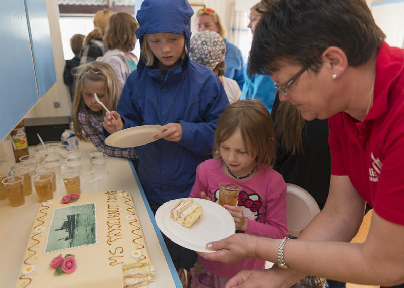 Barn får servert marsipankake under 100-års jubileet til slepebåten «Trysilknut».