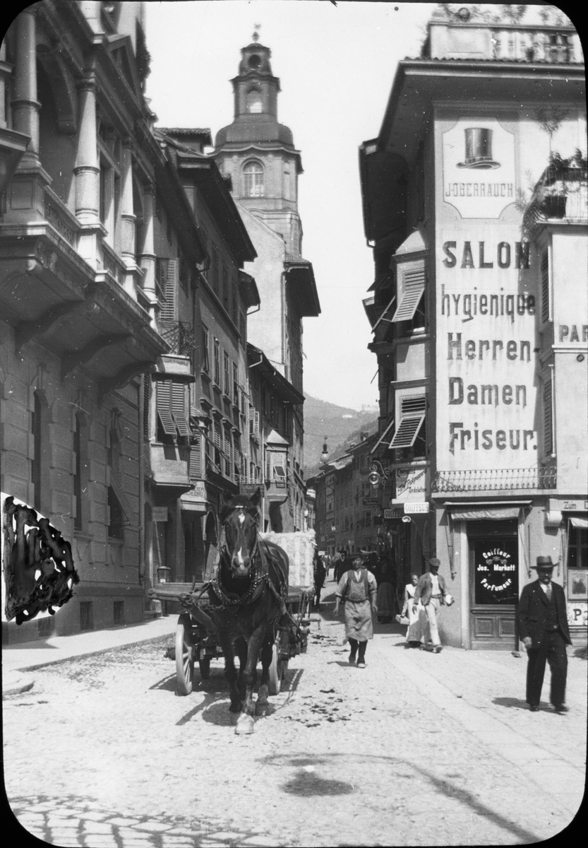Skioptikonbild med motiv från gata i Bozen.
Bilden har förvarats i kartong märkt: Höstresan 1909. Köningssee.
