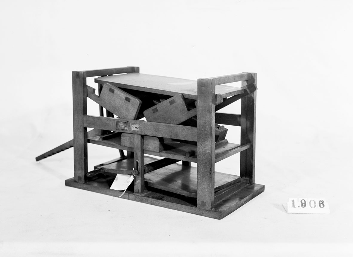 Modell av vevmangel med dubbla kavlar och bord. Text på föremålet: "XVII.E.3. C-e-6".