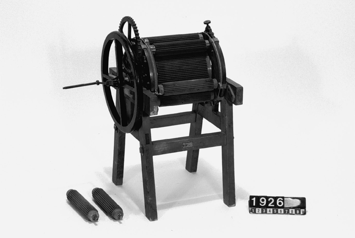 Modell av linbråkningsmaskin. Text på föremålet: "C-a-3 XVII. ? 48", "4". Två rullar har lossnat.